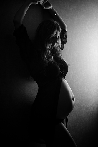 Babybauchfoto Düsseldorf. Frau mit Babybauch. Schwangerschaftsfoto schwarz weiß. Licht von rechts.